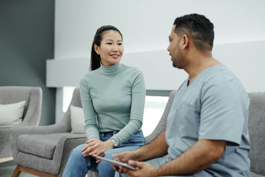 A male doctor explains the situation to a female patient in a comfortable room